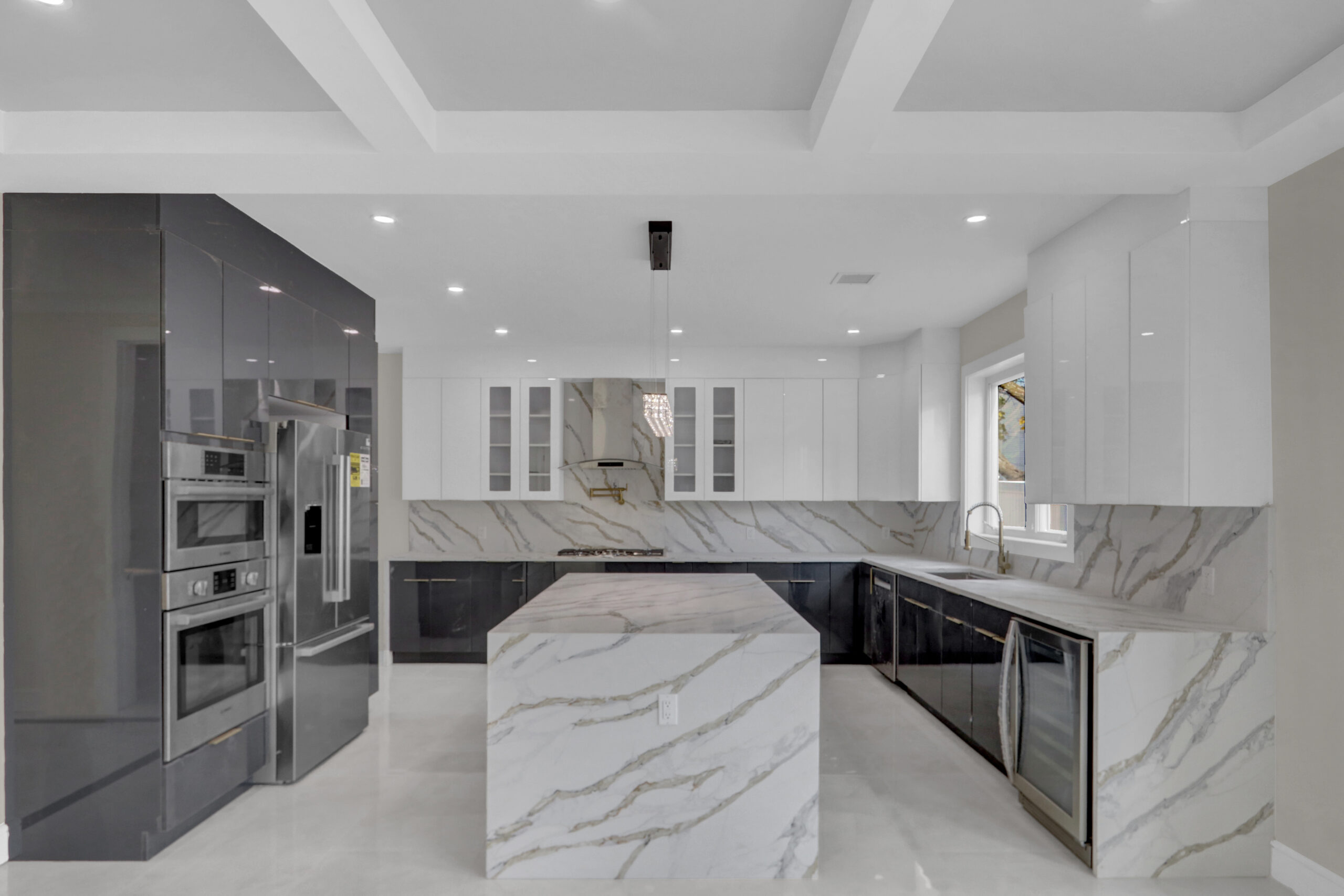 Modern chef's kitchen with waterfall quartz island and gold hardware